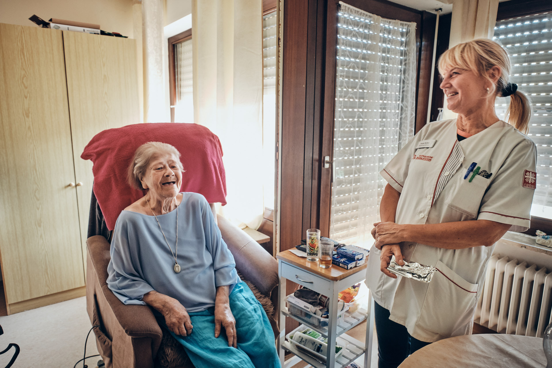 Rentnerin und Pflegekraft lachen gemeinsam